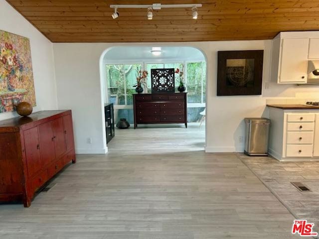 dining space with vaulted ceiling, light wood-type flooring, and wood ceiling