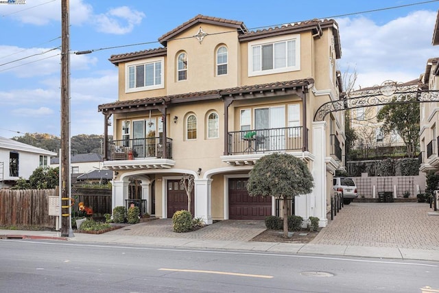 mediterranean / spanish home with a garage and a balcony