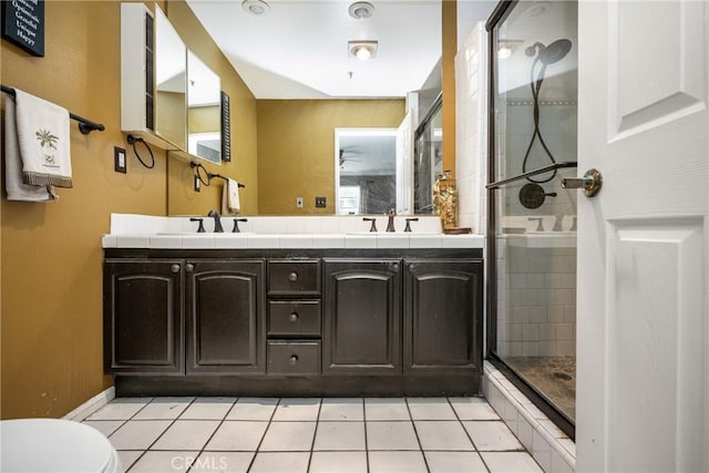 bathroom featuring a shower with door, vanity, tile patterned floors, and toilet