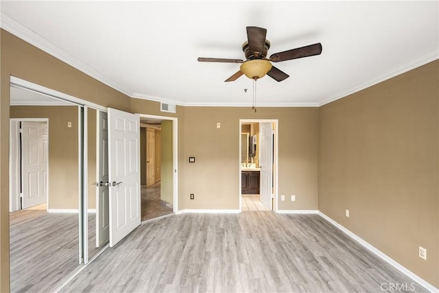 unfurnished bedroom featuring crown molding, light hardwood / wood-style floors, and a closet