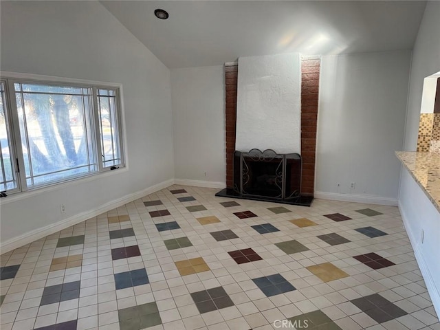 unfurnished living room featuring lofted ceiling, a fireplace, and light tile patterned floors