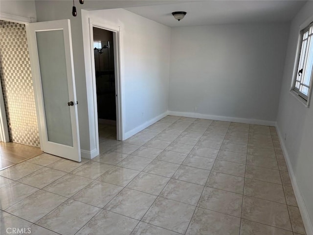 spare room featuring a barn door and light tile patterned floors