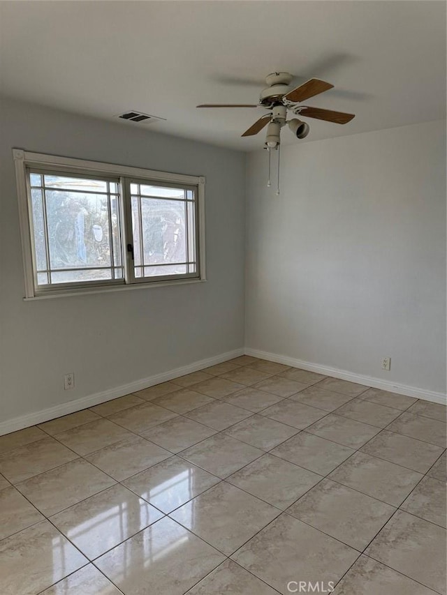 tiled spare room featuring ceiling fan