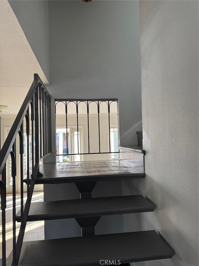 staircase featuring a high ceiling and hardwood / wood-style floors