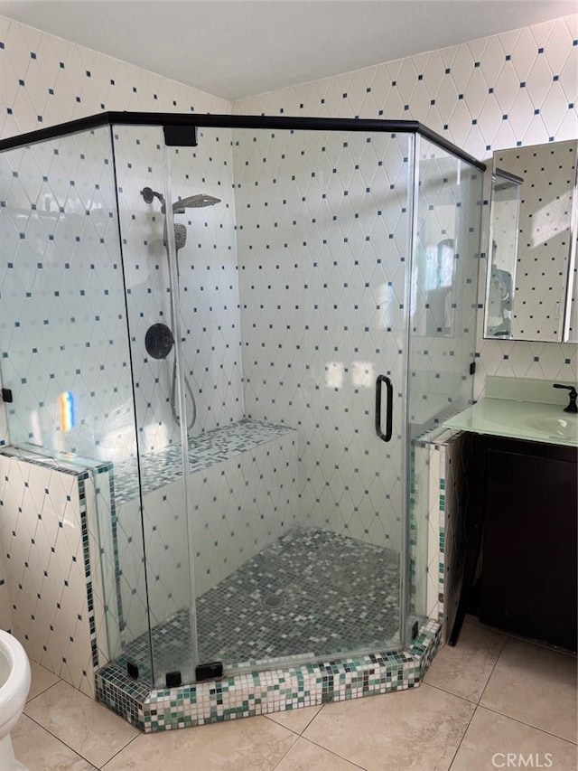 bathroom featuring tile walls, vanity, tile patterned floors, and a shower with door