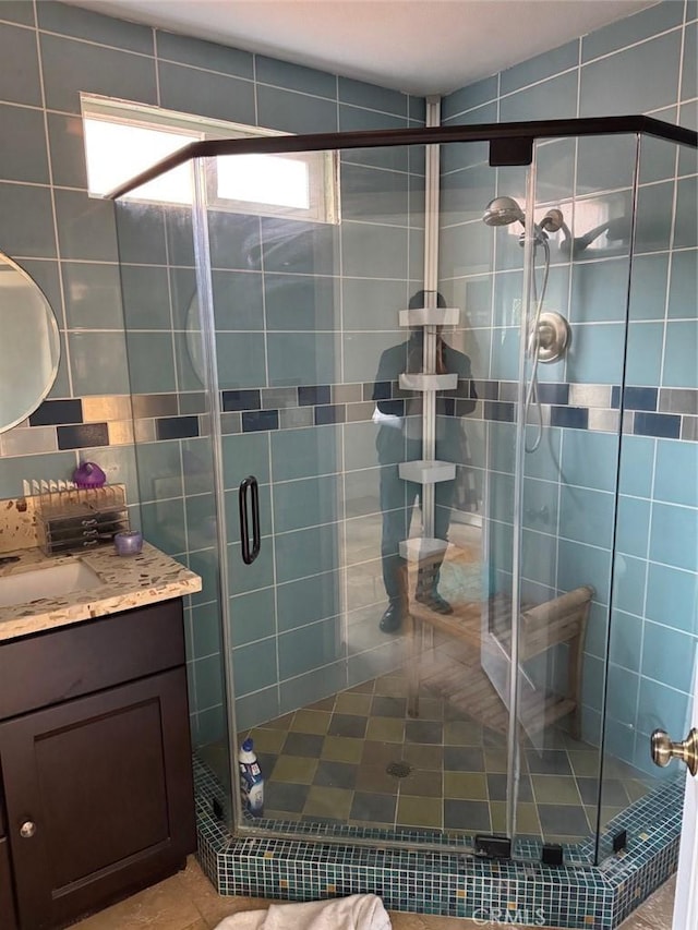 bathroom with a shower with door and vanity