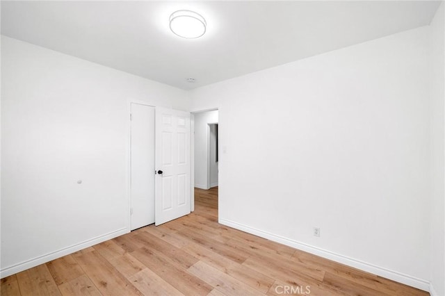 spare room with light wood-style flooring and baseboards