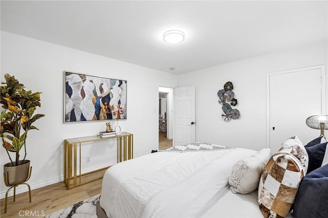 bedroom featuring light wood-style flooring and baseboards