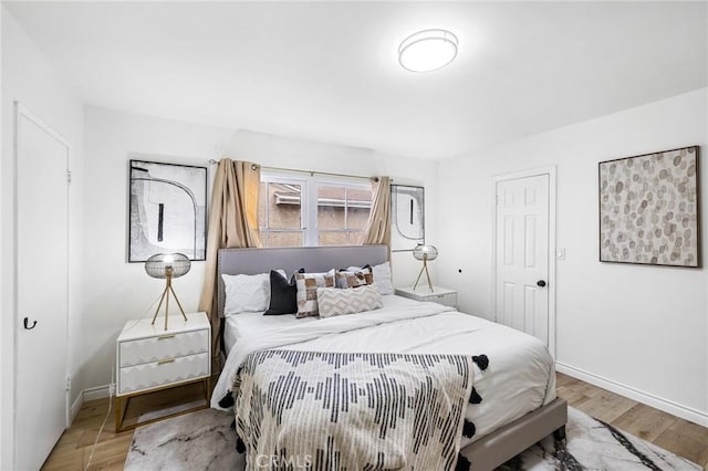 bedroom featuring baseboards and wood finished floors