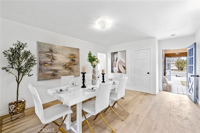 dining room with light wood-type flooring and baseboards