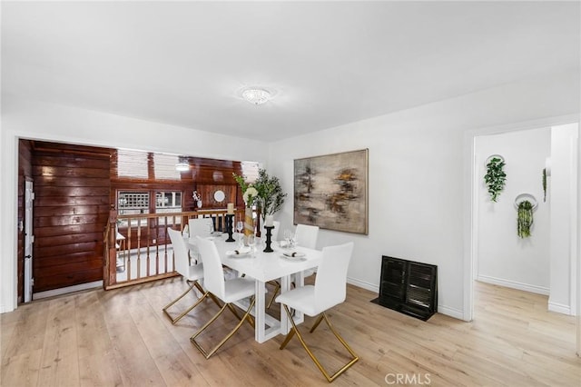 dining space with light wood-style flooring and baseboards