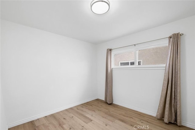 spare room with light wood-style flooring and baseboards