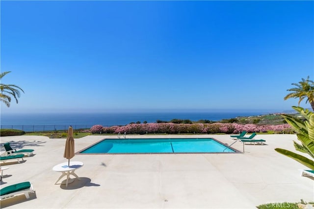 view of swimming pool with a water view and a patio