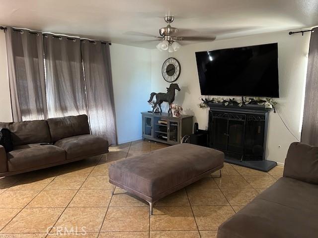 living room featuring light tile patterned flooring and ceiling fan