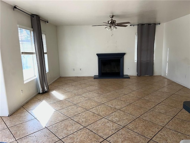 unfurnished living room featuring light tile patterned floors and ceiling fan