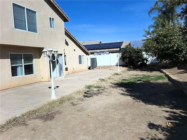 view of property exterior featuring a patio area and solar panels