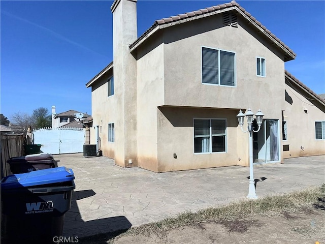 rear view of house featuring a patio and central AC unit