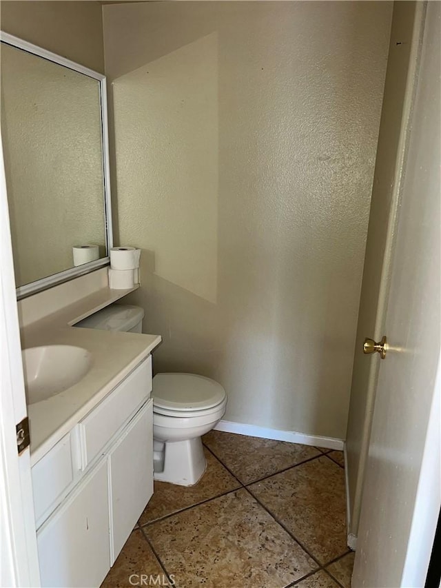 bathroom featuring vanity, tile patterned floors, and toilet