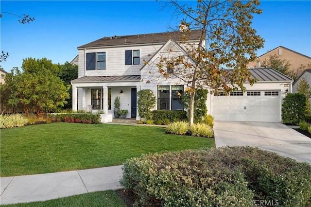 view of front of house with a garage, a front lawn, and covered porch