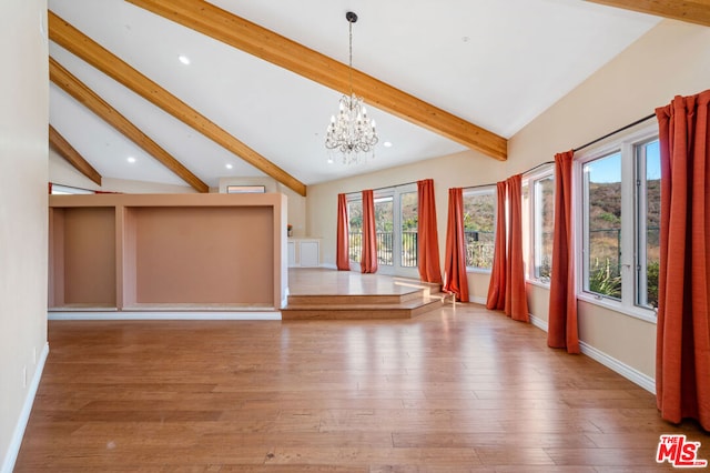 unfurnished living room featuring a notable chandelier, wood-type flooring, plenty of natural light, and vaulted ceiling with beams