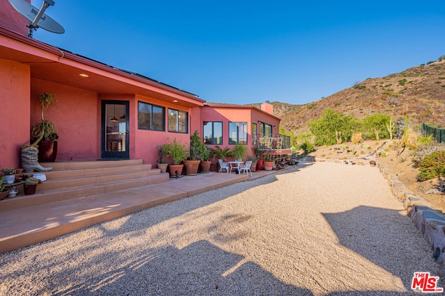 view of front of property with a mountain view and a patio area