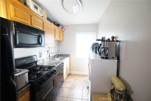 kitchen with light tile patterned floors, sink, light brown cabinets, and black appliances