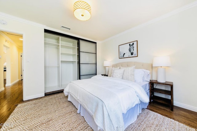 bedroom featuring crown molding, a closet, and hardwood / wood-style flooring