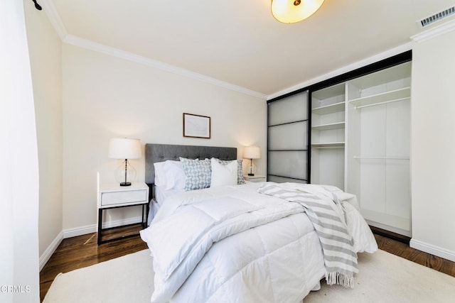 bedroom with crown molding and hardwood / wood-style flooring