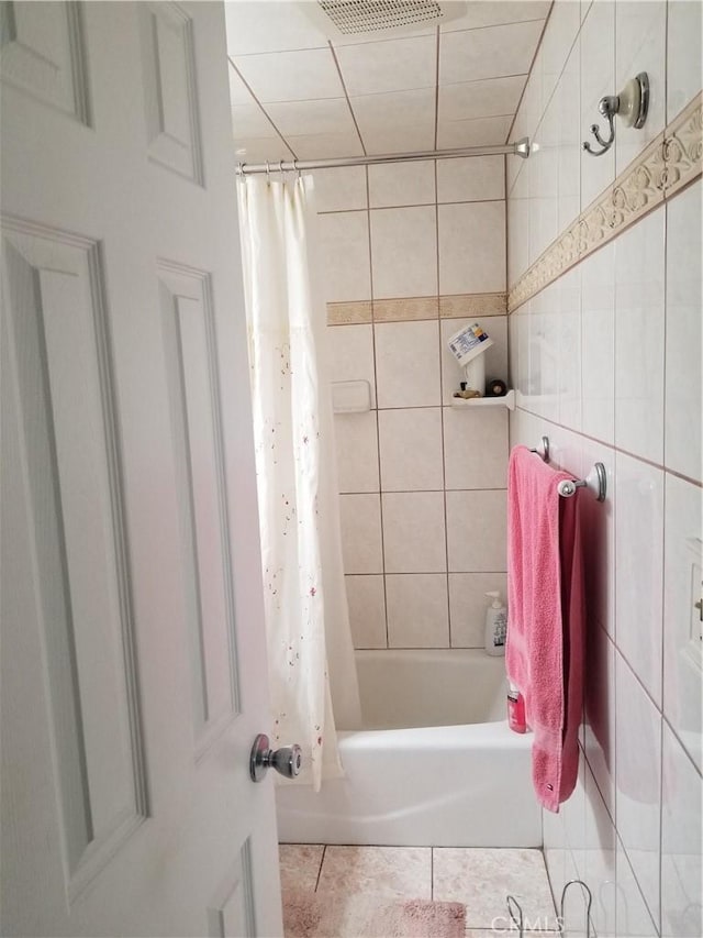 bathroom with tile patterned flooring, visible vents, and shower / bath combo with shower curtain