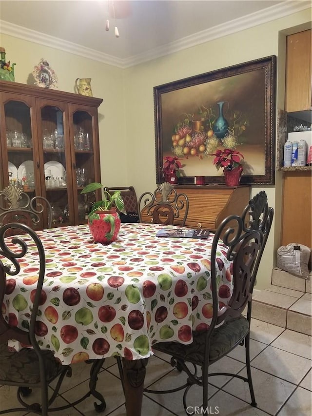 dining space featuring light tile patterned floors and ornamental molding