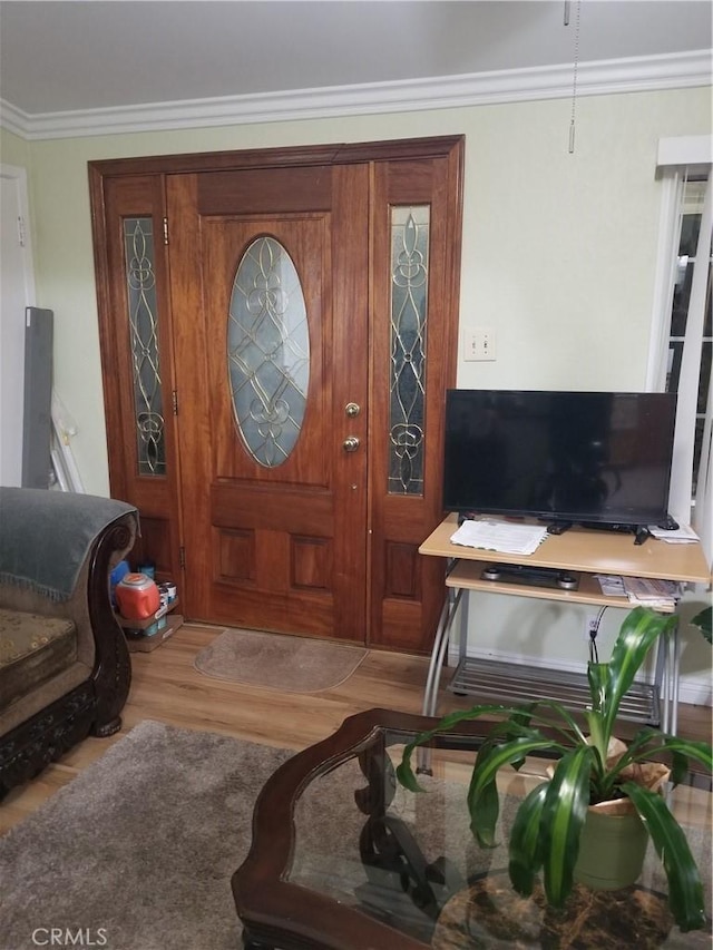 entryway with crown molding and wood finished floors