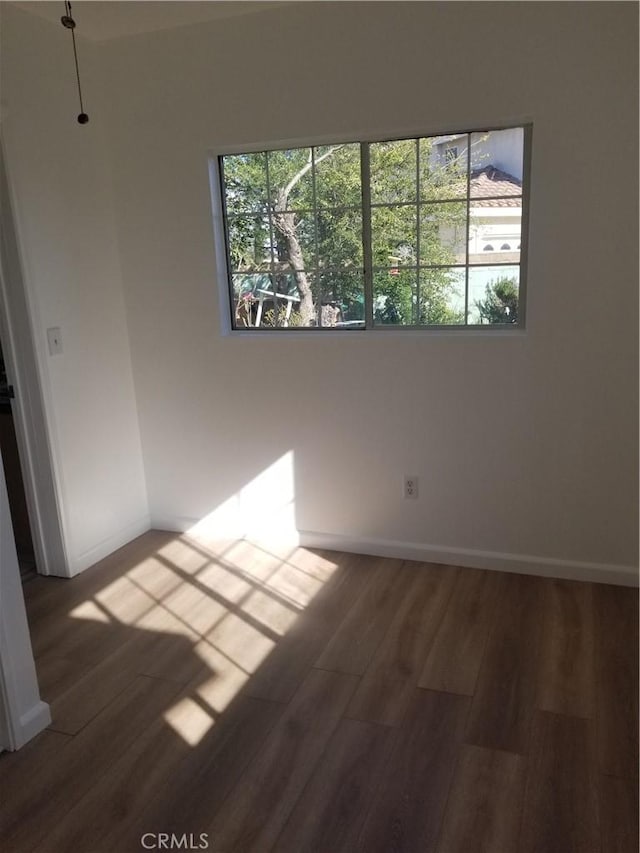 empty room featuring baseboards and wood finished floors