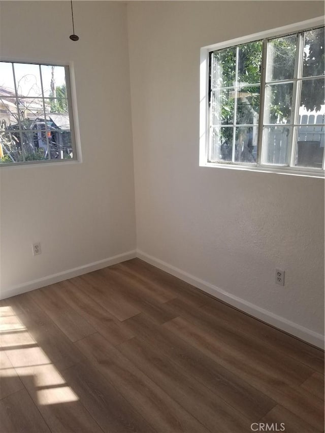 empty room with baseboards and wood finished floors