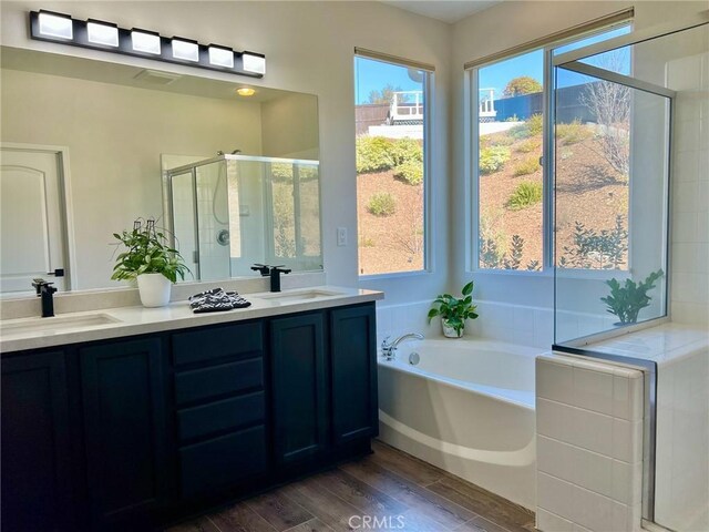 bathroom with vanity, shower with separate bathtub, and hardwood / wood-style floors