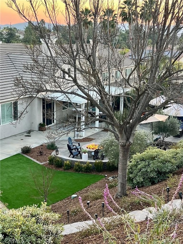 yard at dusk featuring a patio