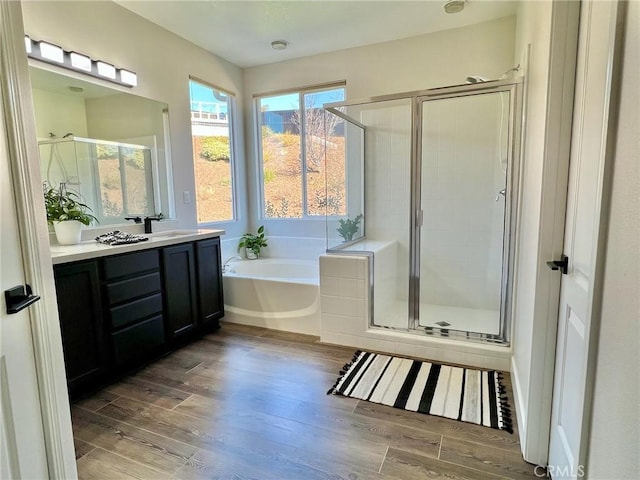 bathroom with hardwood / wood-style flooring, vanity, and independent shower and bath