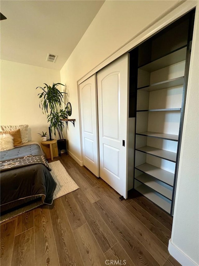 bedroom featuring dark hardwood / wood-style floors and a closet