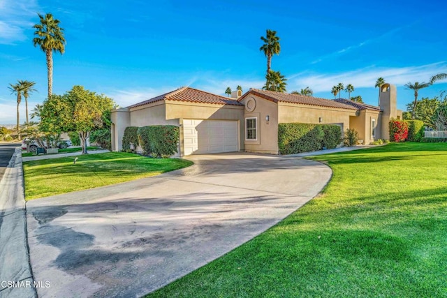 mediterranean / spanish home with a garage and a front lawn