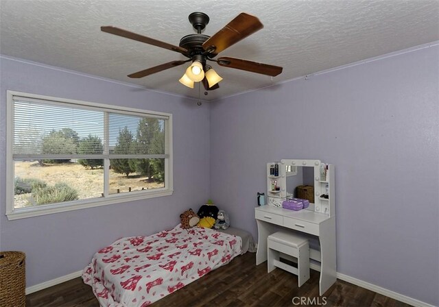 bedroom with ceiling fan, a textured ceiling, baseboards, and wood finished floors