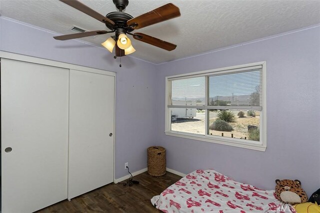 bedroom with a closet, visible vents, a ceiling fan, a textured ceiling, and wood finished floors