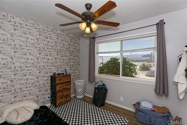 interior space featuring ceiling fan, dark wood-type flooring, and a textured ceiling