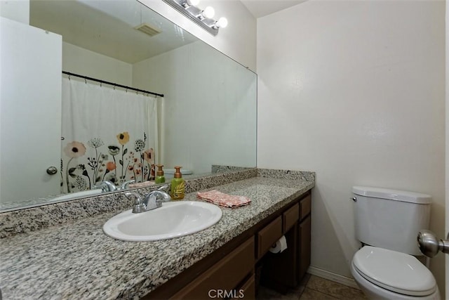 bathroom featuring vanity, tile patterned floors, and toilet