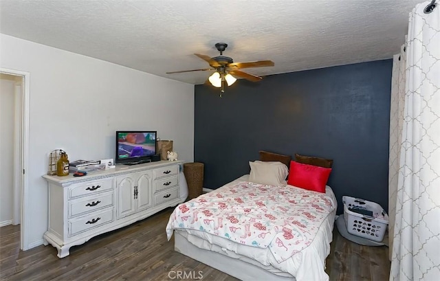 bedroom featuring ceiling fan, dark hardwood / wood-style floors, and a textured ceiling