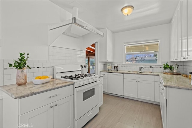 kitchen with sink, white appliances, a healthy amount of sunlight, white cabinets, and decorative backsplash