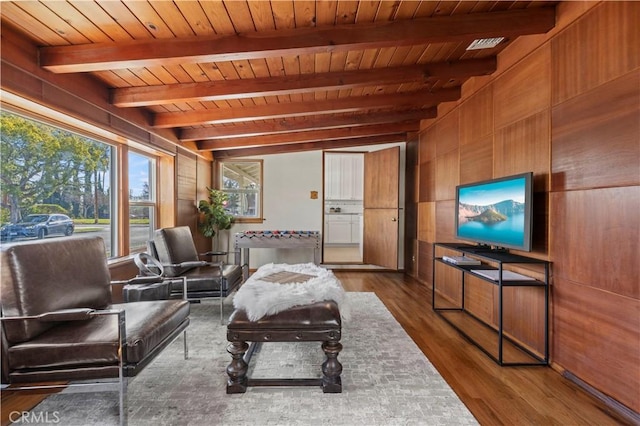 living room with dark hardwood / wood-style flooring, wooden walls, wooden ceiling, and beamed ceiling