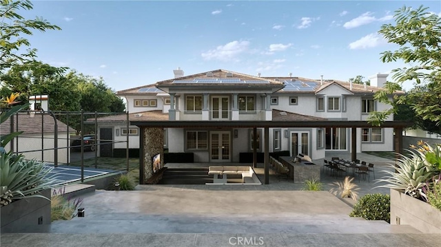 back of property featuring a patio area, outdoor lounge area, french doors, and solar panels