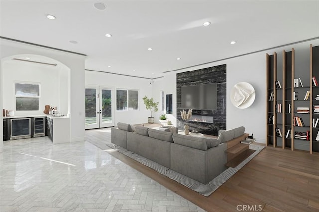 living room with a premium fireplace, wine cooler, and french doors