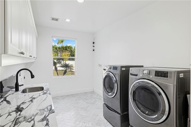 laundry room featuring washer and dryer, sink, cabinets, and light parquet flooring