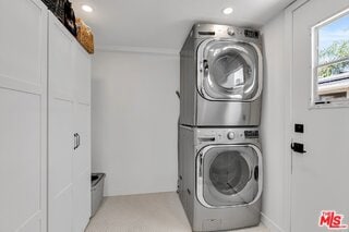 washroom featuring stacked washer / drying machine