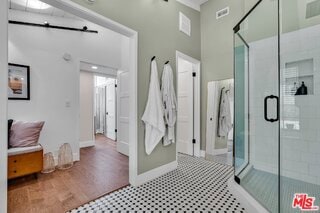 bathroom with a shower with door and a towering ceiling